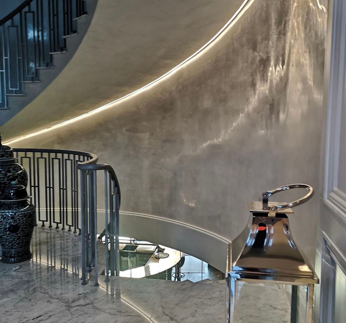 Curved stairwell wall finished in silver polished plaster