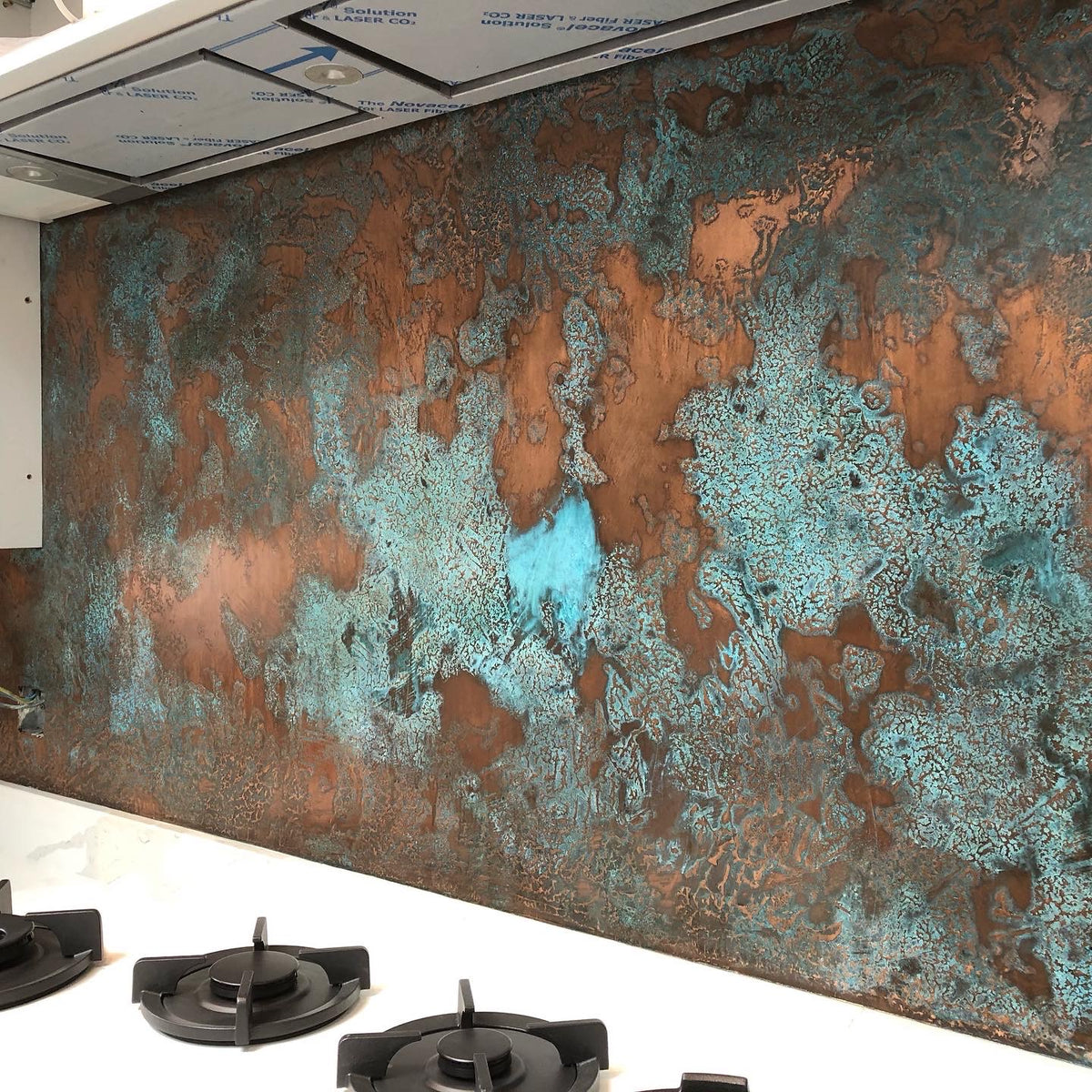 Kitchen splashback in copper liquid metal with a turquoise patina