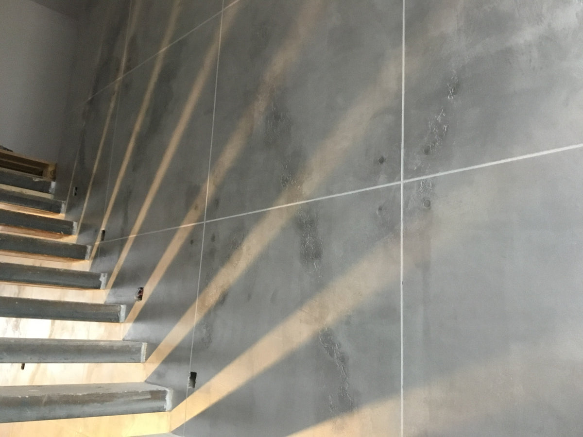 Grey microcement staircase and floor with sunlight across the steps