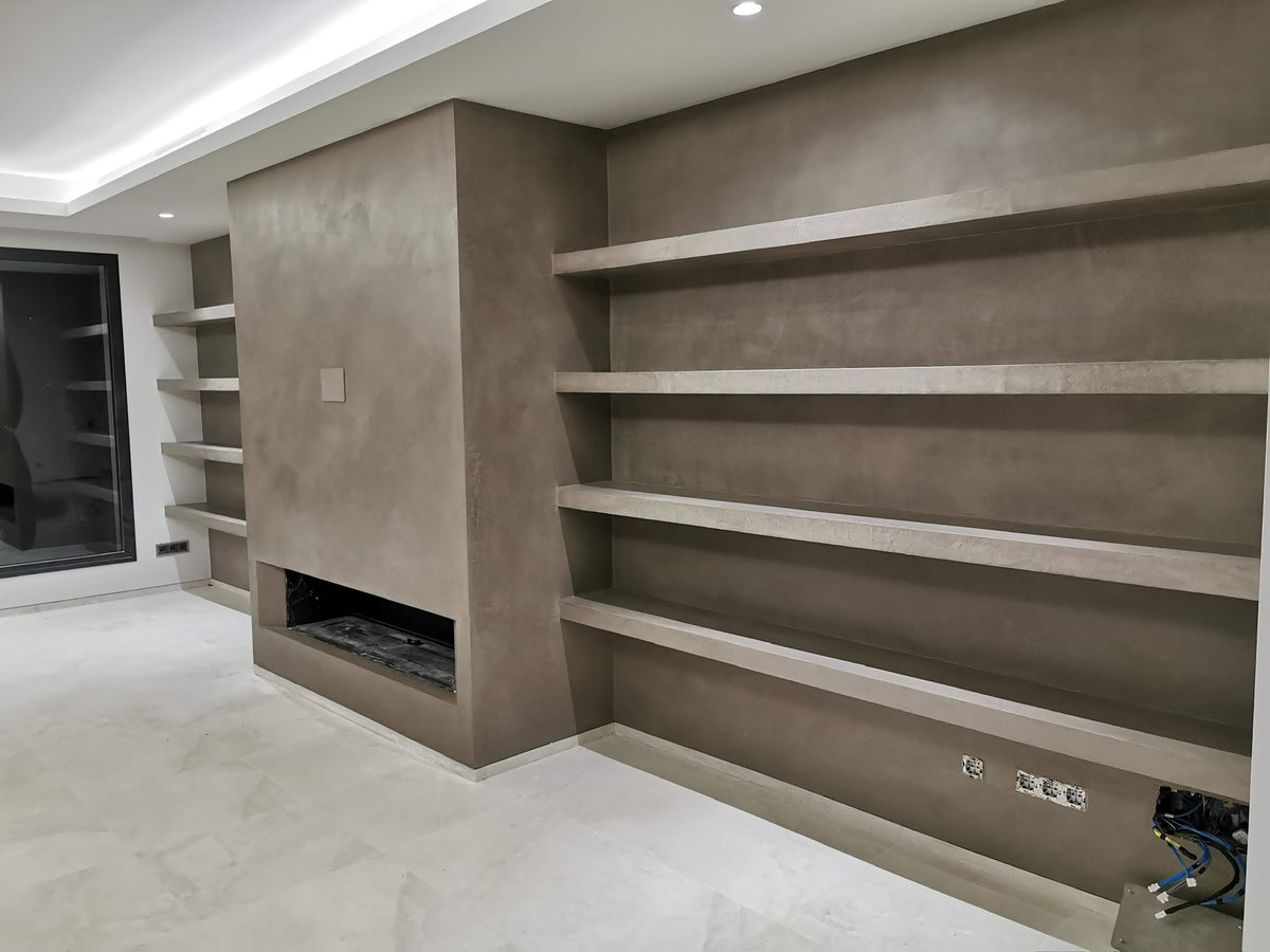 Living room with a taupe microcement fireplace wall and floating shelves