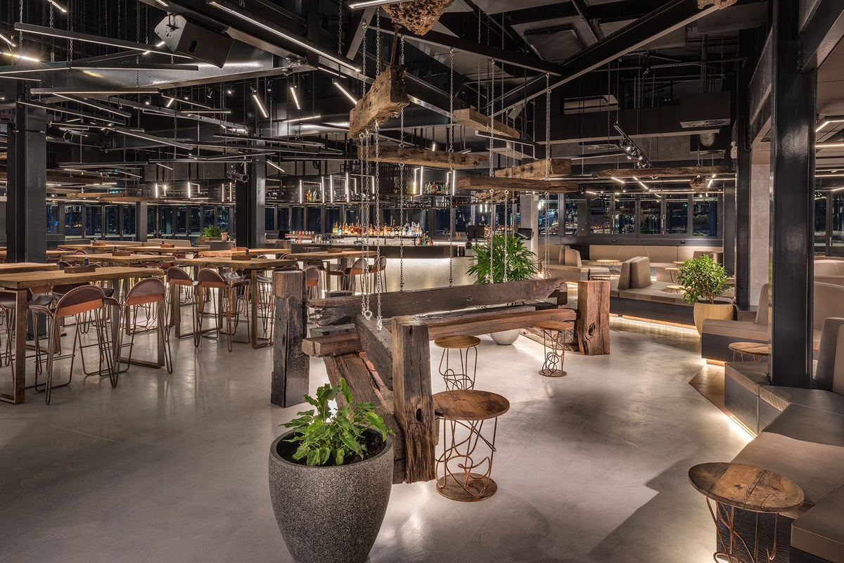 Restaurant with a seamless grey microcement floor and timber bench seating