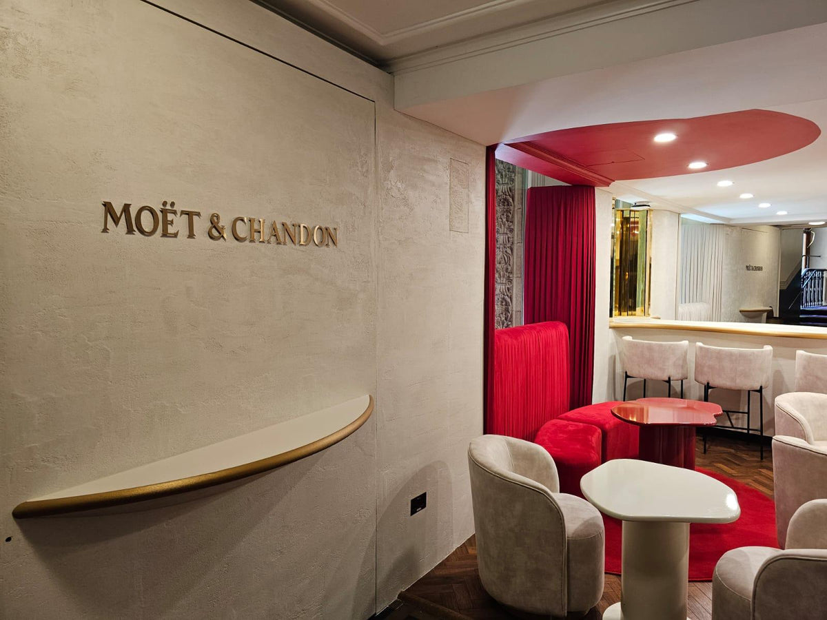 Moët & Chandon champagne bar with a textured plaster wall and gold lettering