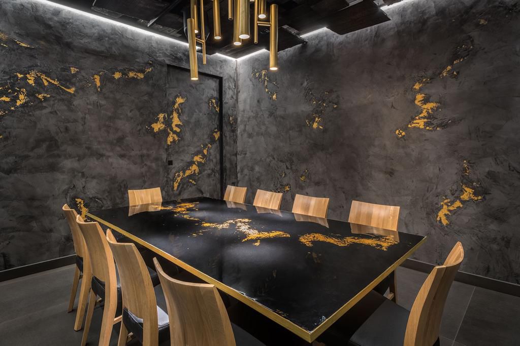 Private dining room with charcoal walls veined in gold liquid metal
