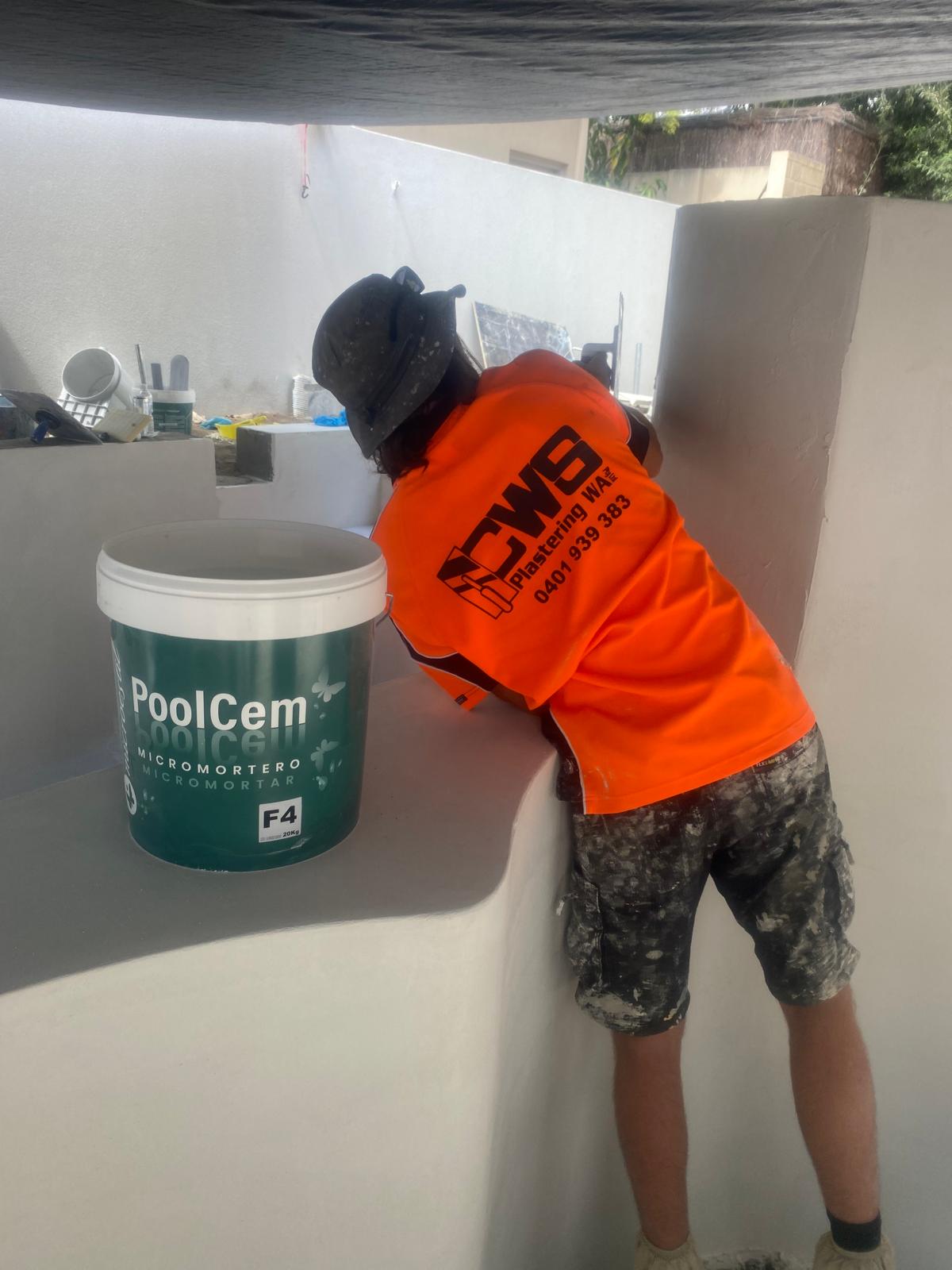 Plasterer applying PoolCem microcement to a pool wall