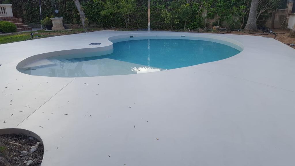 Kidney-shaped pool with seamless microcement deck