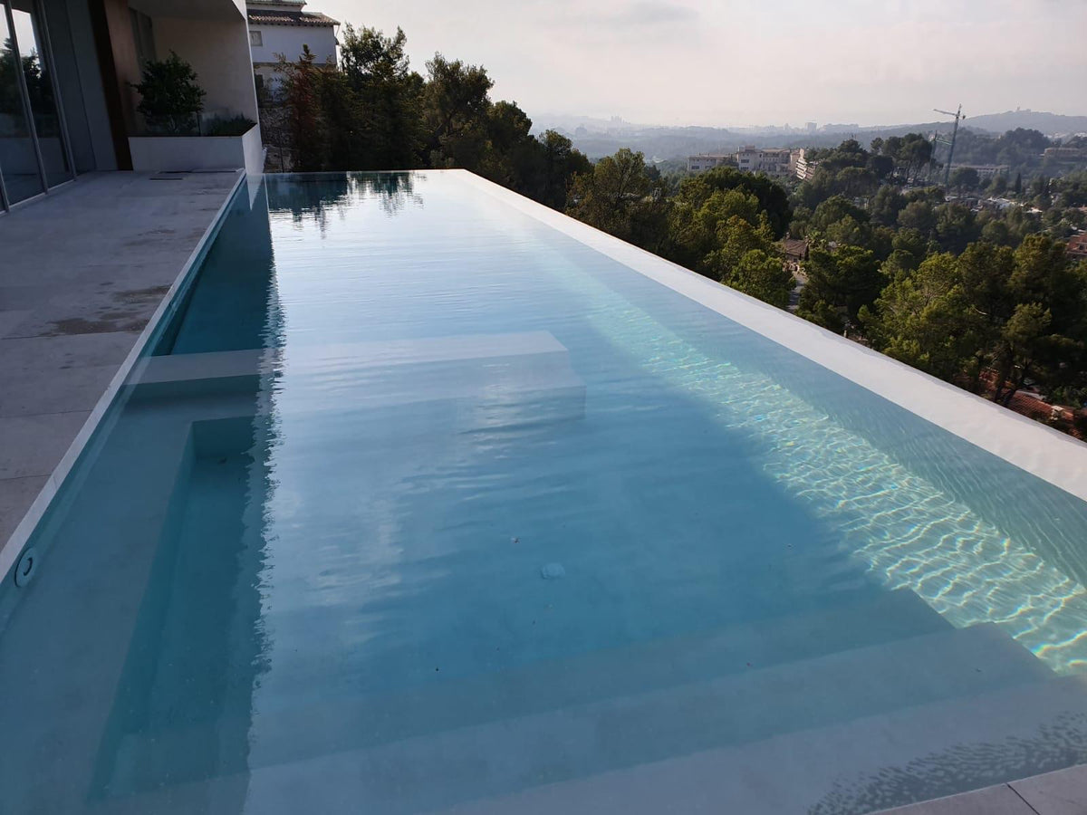 Infinity pool in microcement overlooking wooded hills