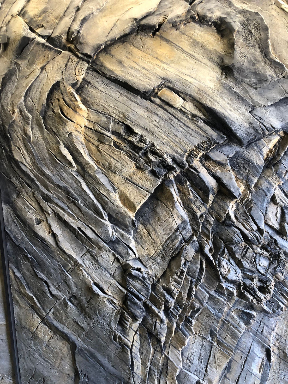Layered grey and ochre faux rock wall with hand-carved strata