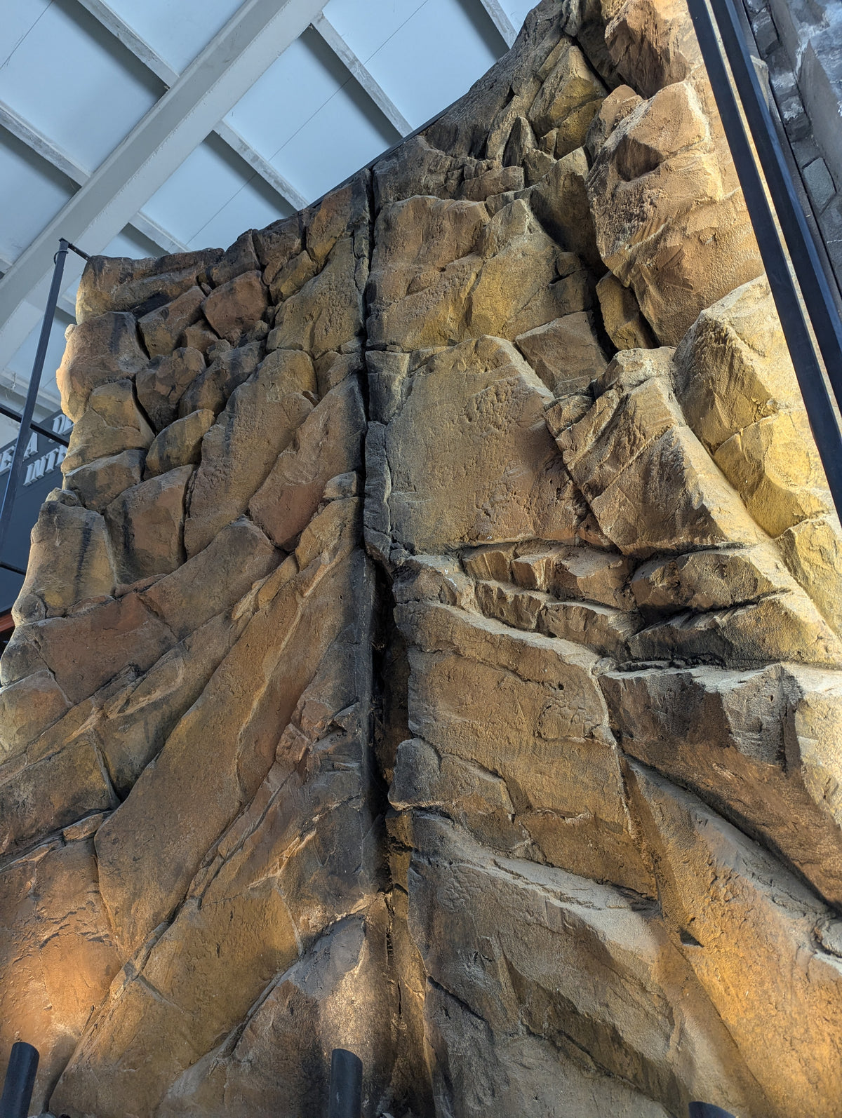 Tall ochre sandstone-effect rock wall feature