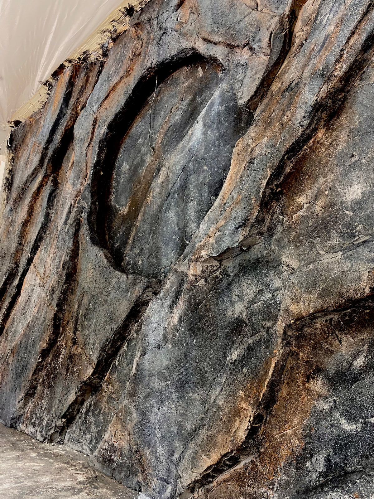 Dark grey and rust faux rock wall finished on site